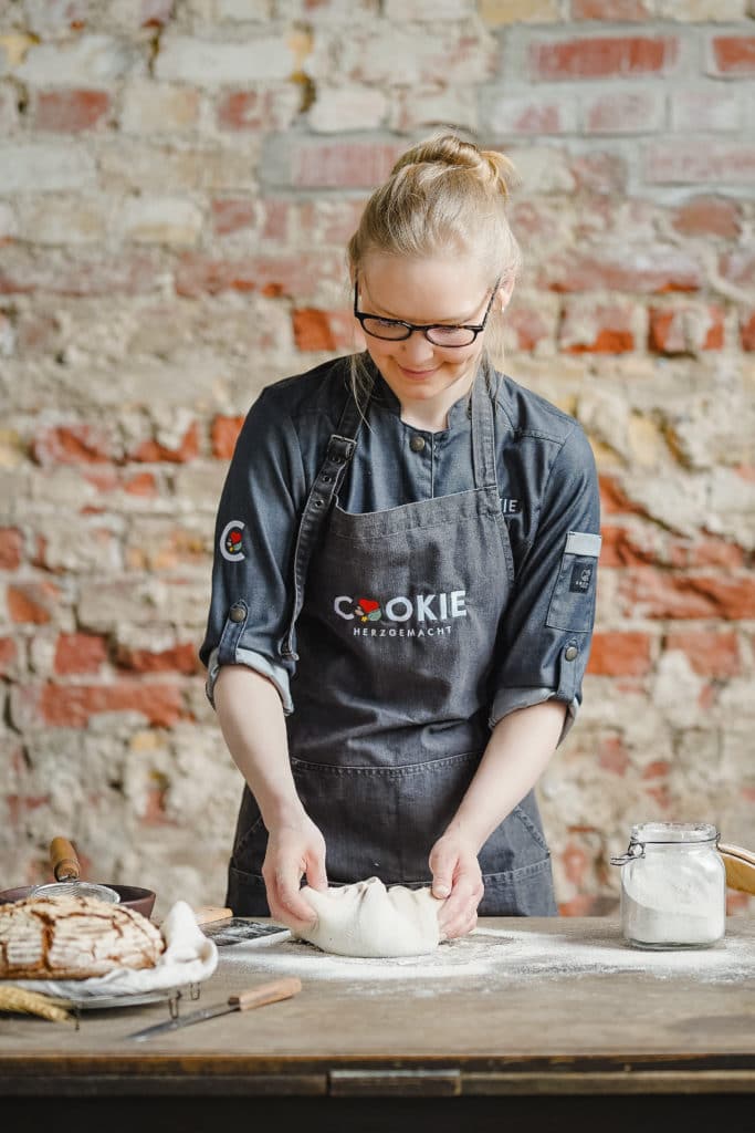Brotteig formen auf einem Holztisch mit Sonja Bauer. Glossar über Fachbegriffe Brot.